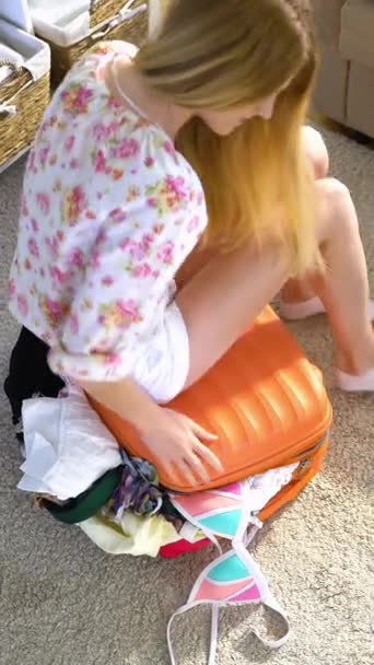 Egy Fiatal Megpróbálja Bezárni Csordultig Narancssárga Bőröndöm Szemközti Nézet — Stock videók