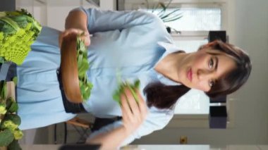 Güzel genç bir kadın akıllı telefonuyla evdeki lezzetli ve sağlıklı yemekleri anlatan video blogu yayınlıyor.
