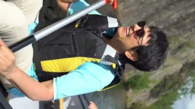 Yaşlı çift Finlandiya 'da bir orman gölünde kano yapıyor. Aktif emekliler açık hava sporlarını severler. Sportif yaşlı insanlar doğayla eğleniyorlar. Dikey odaklı bir video.