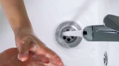 Küçük kız banyoda ellerini yıkıyor, Coronavirus el temizliği için ellerini yıkıyor.