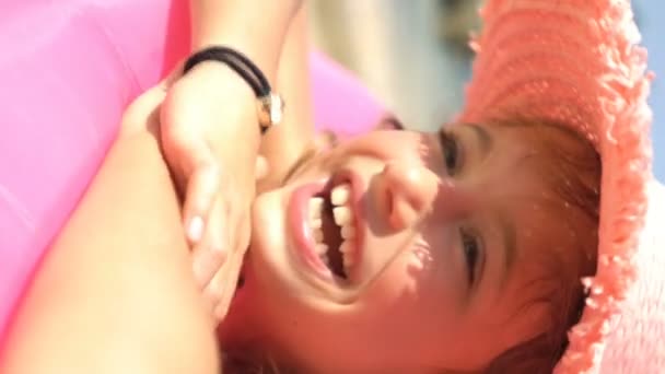 Mała Szczęśliwa Dziewczynka Różowym Słomkowym Kapeluszu Leżąca Dmuchanej Różowej Sofie — Wideo stockowe