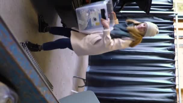 一名年轻妇女将旧电器放在Hsy分选站的垃圾箱中 该分选站是废物 建筑废物和电气设备的分选和再循环中心 — 图库视频影像