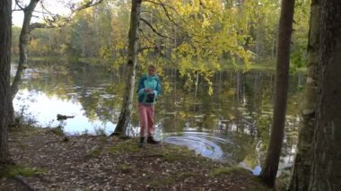 Genç bir kadın orman gölünden su çeker ve açık ateşte kahve yapar. Finlandiya 'da yürüyüş yaparken sessizliğin ve temiz havanın tadını çıkaran iki bayan arkadaş.