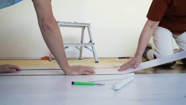 Dojrzałe Małżeństwo Instalujące Nowe Drewniane Podłogi Laminowane Ciepłej Podłodze Remont — Wideo stockowe