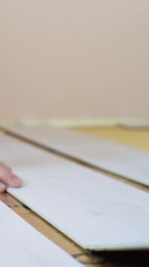 Olgun evli bir çift, sıcak bir zemine yeni ahşap döşemeler döşüyorlar. Yenileme, yeni hayat konsepti