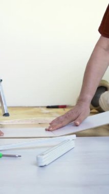 Olgun evli bir çift, sıcak bir zemine yeni ahşap döşemeler döşüyorlar. Yenileme, yeni hayat konsepti