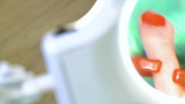 Pedikür uzmanı güzellik salonunda estetik pedikür yapıyor. Bir pedikür uzmanı genç bir kadının tırnaklarını cilalar.