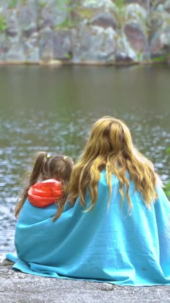 Una Giovane Madre Con Sua Figlioletta Seduta Sulla Riva Rocciosa — Video Stock