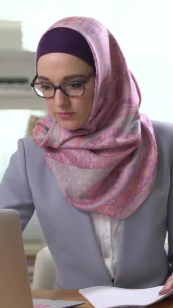 伝統的なスカーフを着て笑ってカメラを見てプロの若いイスラム教徒のビジネス女性の肖像画 スマートフォンの画面のための垂直ビデオ ターゲットソーシャルメディアプラットフォームやWebブラウザのための — ストック動画