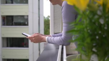 Genç çekici bir kadın düşüyor, balkonda dururken akıllı telefonunu yakalayıp kırmaya çalışıyor. Kaza ve sigorta kavramı