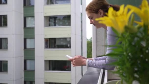 Młoda Atrakcyjna Kobieta Spada Próbując Złapać Rozwalić Smartfona Stojąc Balkonie — Wideo stockowe
