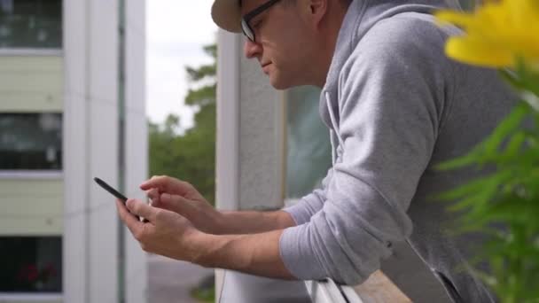 Mężczyzna Średnim Wieku Spada Próbuje Złapać Rozwalić Smartfona Stojąc Balkonie — Wideo stockowe