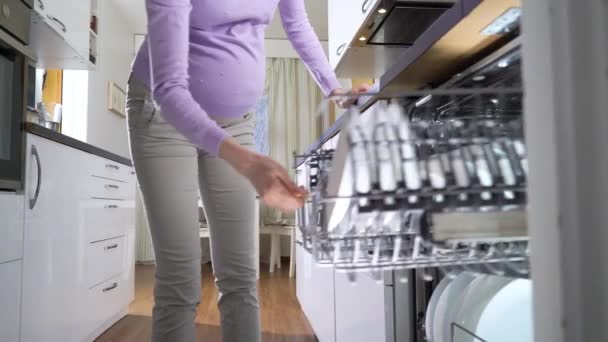 Беременная Молодая Женщина Вынимает Чистые Тарелки Посудомоечной Машины Ярко Солнечной Лицензионные Стоковые Видеоролики