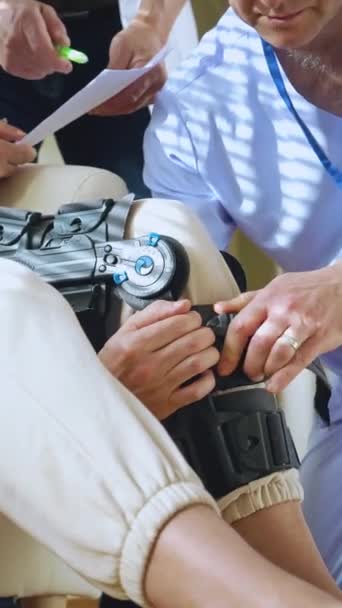 Male Nurse Helps Put Bondage Medical Splint Knee Brace Leg — Stock Video