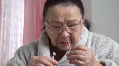 Hızlı Antikor Testi yapan yaşlı kadın SARS-CoV-2, Covid-19, Coronavirus evde. İzleme görüntüsü.