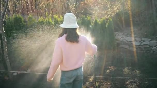 Gadis Remaja Tukang Kebun Menyirami Kebun Dengan Selang Musim Semi Stok Video Bebas Royalti