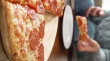 Aile pizzasını paylaşıyor. İnsan elleri sıcak İtalyan pizza pepperonisinden dilimler alıyor. İzleme görüntüsü.