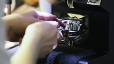 Barista kahve dükkanında karıştırıcı kullanarak elle kahve yapıyor. Elleri yakın çekim. Kahve aroması ve sıcak dükkan havası.
