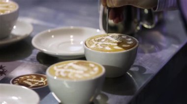 Kahve dükkanında, restoranda, barda ya da barda kahve hazırlamak için süt dolduran baristaların yakın çekimleri. Latte sanat, kahve hazırlama, yaşam tarzı ve hizmet.