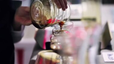 Barista kahve bardaklarını dolduruyor..