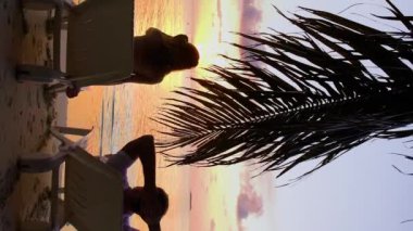 Çift tropik sahilde günbatımı hayran.