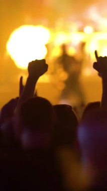 Büyük bir kalabalık bir rock konserinde. Ellerini sallayarak hayranları.