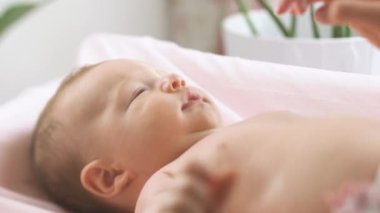 Anne kuru cilde nemlendirici krem sürüyor. Hijyen, bebek bakımı ve sağlık hizmetleri kavramı.