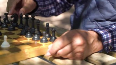 Bahçede satranç oynayan kıdemli bir adam. Boş zaman aktivitesi, akıl sağlığı ve dolu yaşam kavramı yaşlılık, spor, eğlence, eski nesil.