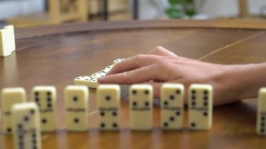 Domino oyunu. Aile, genç bir kadın ve kızı oturma odasında oyun oynuyorlar.