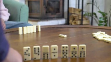 Domino oyunu. Aile, genç bir kadın ve kızı oturma odasında oyun oynuyorlar.