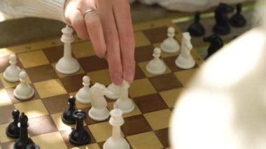 Yaşlı adam ve genç kadın bahçede satranç oynuyorlar. Boş zaman aktivitesi, akıl sağlığı ve yaşlılık, spor, eğlence, eski nesil, mutlu emekli insanlar, sağlık ve