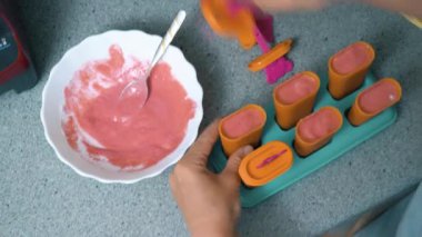 Ev yapımı buzlu şeker, dondurmalı lolipop, dondurulmuş meyve suyu. Kadınların elleri dondurma kalıbını tutar..