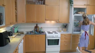 Bir kadın ev mutfağında tavuk bacağı pişiriyor. Evde yemek hazırlıyorum..