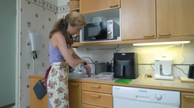 Ev hanımı mutfakta keskin bir bıçakla çiğ tavuk eti kesiyor. Bir kadın mutfakta tavuk bacağı pişirir. Evde yemek hazırlıyorum..