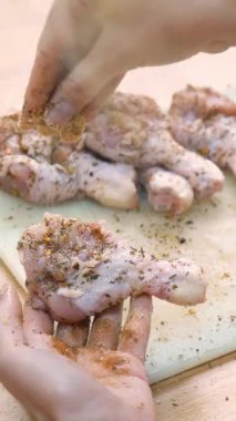 Ev hanımı mutfaktaki kesme tahtasındaki çiğ tavuğu tuzlayıp çeşnilendiriyor. Evde yemek hazırlıyorum..