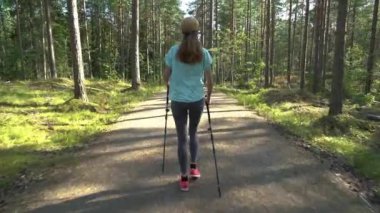 Aktif kadın Finlandiya 'da ulusal bir parkta yürüyüş yapıyor, parkta spor yapıyor, egzersiz yaparak formda kalıyor.