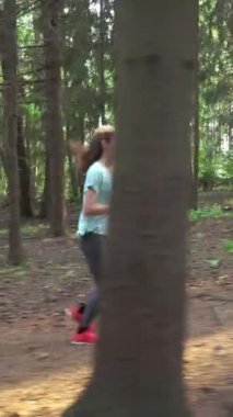 Finlandiya 'da ulusal bir parkta koşan atletik genç kadın, ormanda spor yapıyor, egzersiz yaparak formda kalıyor.