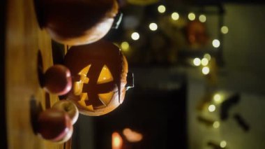 Cadılar Bayramı balkabağı Jack-O-Lantern eski ahşap masada yanan şömine arkaplanı ile Cadılar Bayramı arifesinde bir oturma odasında.