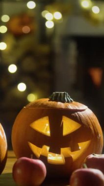 Cadılar Bayramı balkabağı Jack-O-Lantern eski ahşap masada yanan şömine arkaplanı ile Cadılar Bayramı arifesinde bir oturma odasında.