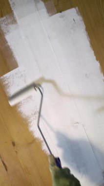 Ahşap yüzeyi boya rulosuyla beyaza boyuyorum. Kendin tamir et, kendin tamir et ve evi geliştir.