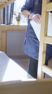 Otel odasında yatak değiştiren bir kadın hizmetçi. Hizmetçi temiz ve düzenli bir yatak yapıyor. Bir çalışan pansiyonda bir odayı temizliyor. Otel sektöründe kaliteli hizmet kavramı