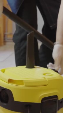 Orta yaşlı bir erkek otel odasını elektrikli süpürgeyle temizliyor. Otel işi konsepti üzerine ticari temizlik şirketi.