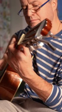 Orta yaşlı bir adam rahat bir oturma odasında tek başına akustik gitarını çalar. Kendi solo çalışmalarına dalmış kişisel ifade ve müzikal adanmışlıktan zevk alıyor. Rahat ve samimi.