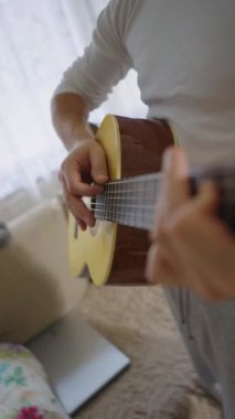 Orta yaşlı bir adam rahat bir oturma odasında tek başına akustik gitarını çalar. Kendi solo çalışmalarına dalmış kişisel ifade ve müzikal adanmışlıktan zevk alıyor. Rahat ve samimi.