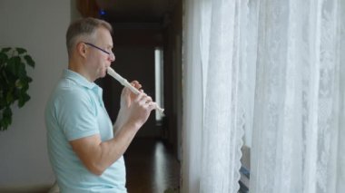 Orta yaşlı bir adam rahat bir oturma odasında flüt çalar. Kendi solo çalışmalarına dalmış kişisel ifade ve müzikal adanmışlıktan zevk alıyor. Rahat ve samimi bir ortam.
