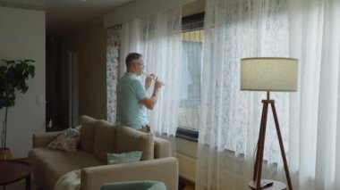 Orta yaşlı bir adam rahat bir oturma odasında flüt çalar. Kendi solo çalışmalarına dalmış kişisel ifade ve müzikal adanmışlıktan zevk alıyor. Rahat ve samimi bir ortam.