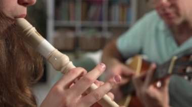Orta yaşlı bir adam ve 12 yaşında bir kız birlikte müzik keyfi yapıyorlar. O gitar çalıyor, o da rahat bir ortamda flüt çalıyor.