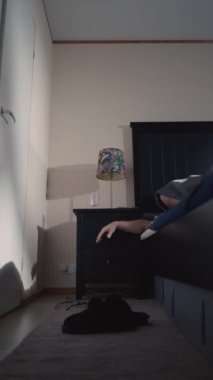 Orta yaşlı bir erkek, Finlandiya 'da işe hazırlanmak için İskandinav tarzı rahat bir yatak odasında gün doğmadan erken uyanır..