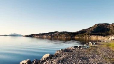 Günbatımında Norveç 'in batısındaki Mjomna adasındaki sahil şeridi. Mjomna Norveç 'in batı kıyısında büyük bir ada ve köydür.