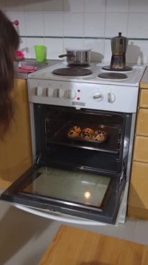 Bir kız sıcak bir mutfakta yabanmersinli kek pişiriyor..